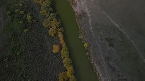 Drone ascent above narrow river with contrasting riverbanks in Kazakh steppe Stock Footage 334326020