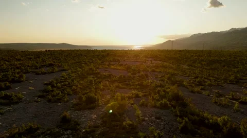 Drone ascent revealing quiet bay with coves and sunset reflections Stock Footage 323504235