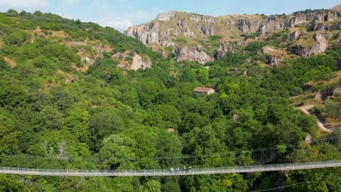 Drone Ascent from Suspension Bridge to Cave Cliffs in Armenia Stock Footage 344470493