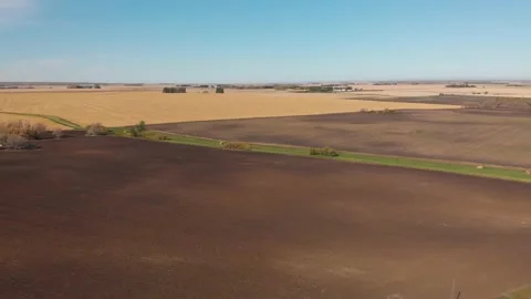 Drone backing up and rising over autumn farm fields showing plowed land Stock Footage 140121627