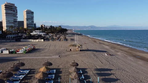 Drone Backwards Flight Over Sunbeds with Parasol on Torremolinos Beach Stock Footage 310587014
