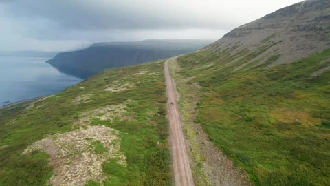 Drone Behind Red Car on Remote West Fjord Road Incredible Iceland Aerial Stock Footage 258485914