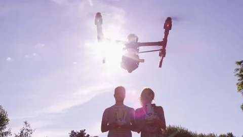 Drone Being Flown By Engineering Partners In Silhouette Backlit By The Sun Slow Видео 82577937
