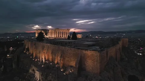 Drone bird's eye view of the Acropolis of Athens during blue hour, city lights Stock Footage 251077916