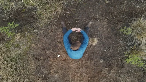 Drone Birds Eye View of Man Sitting At Peat Bog, 4K 動画素材 219084337