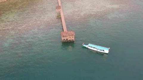 Drone, boat pulling away from jetty Stock Footage 131433244