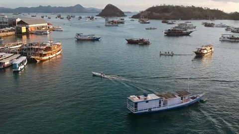 Drone, boat pulling into busy harbour at sunset, Labuan Bajo Indonesia Video stock 131433313