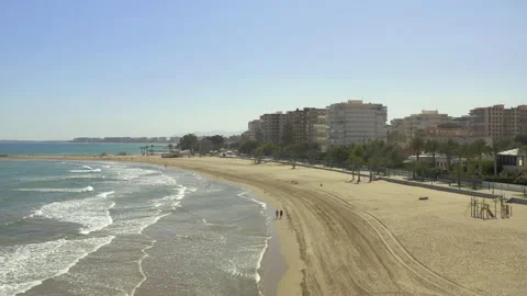 Drone booming down from high angle to land on beach 스톡 동영상 150406017