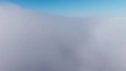 Drone Breaks Through Foggy Cloud Layer into Clear Blue Sky Above Video stock 314497109
