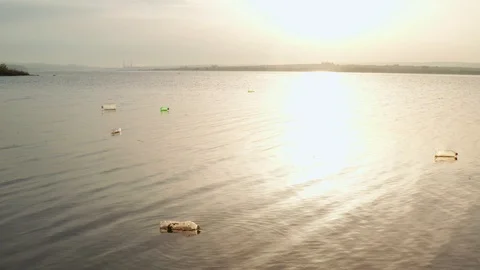 Drone on the calm surface sea water with floating plastic bottles and garbage Video stock 108484201
