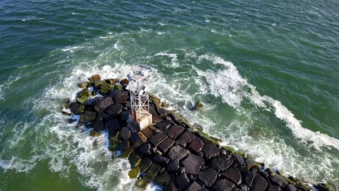 Drone cam hovers over the jetty near the inlet in Ocean City MD on a clear day Stock Footage 89449919