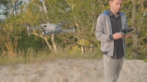 Drone camera aircraft remote controlled by young Caucasian man Stock Footage 219920524