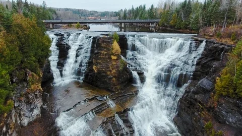 Drone camera is approaching a ledge of a cliff between two waterfalls Video stock 126080607