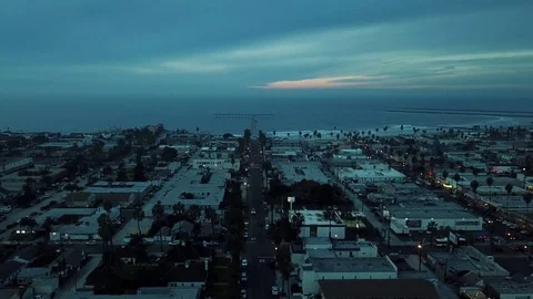 Drone Camera ascends slowly over sleepy beach town after sunset Stock Footage 84774320