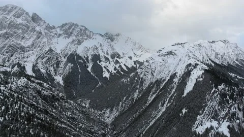 Drone camera captures black mountain slopes with snowy peaks in Alberta Video stock 143233691