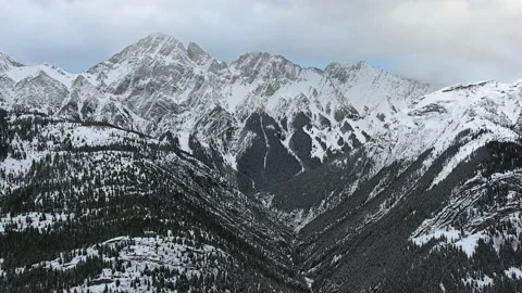 The drone camera captures stunning snowy mountains with black slopes in Alberta Video stock 143233595