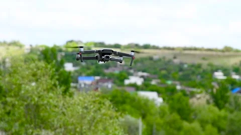 Drone with a camera flies against the background of trees and sky Stock Footage 306548877