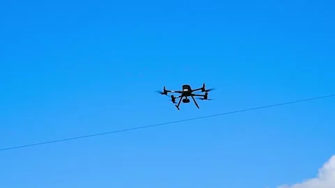 Drone with a camera flies against the background of sky Stock Footage 331206087
