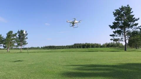 Drone with camera flies up over the golf course Stock Photos