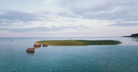 A drone camera flies over the shallow waters of the sea bay along the coastline. Stock Footage 146702229