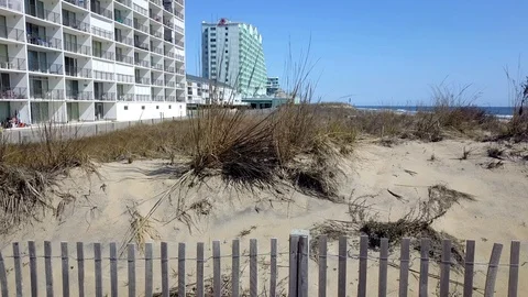 Drone camera flies sideways along beach sand dune in Ocean City, Maryland Stock Footage 89452181