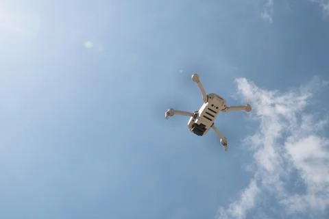 Drone with camera flying over the blue cloudy sky. Aerial landscape photography. Photos