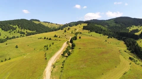 Drone camera flying over a dirt road leading to the top of the mountain Stock Footage 157363089