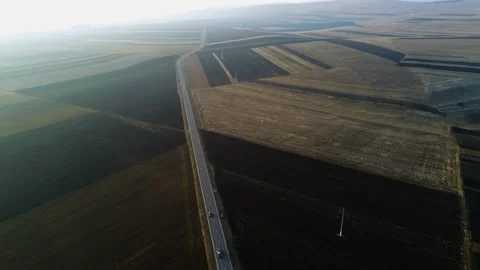 Drone camera flying over empty agricultural fields at sunset in harsh sunlight Stock Footage 149263339