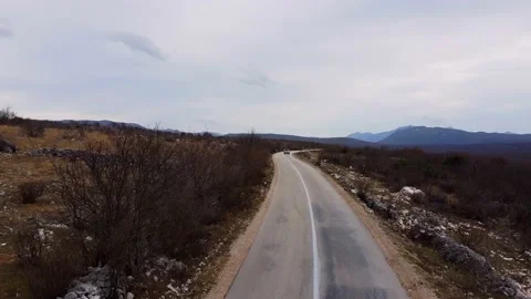 Drone with camera is flying over highway where cars are driving. Bleak landscape Video stock 163388208