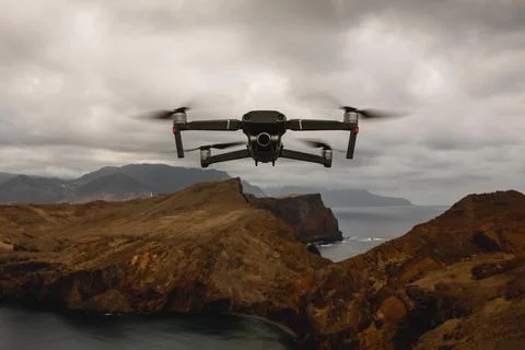 Drone with camera flying over the mountains. Stock Photos