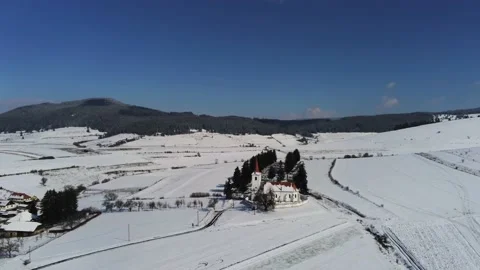 Drone camera flying over a small catholic church at wintertime in Transylvania Stock Footage 150683357