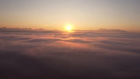 Drone camera flying over thick fog above beautiful ocean of clouds at sunrise. Stock Footage 259134579