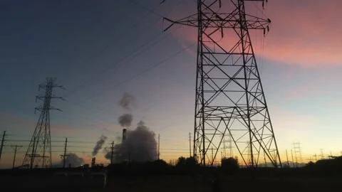Drone camera flys past power towers in front of lovely sunset Stock Footage 141425279