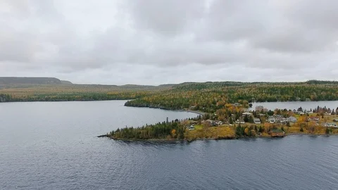 The drone camera moves away from the shore with a dense autumn forest Video stock 126078720