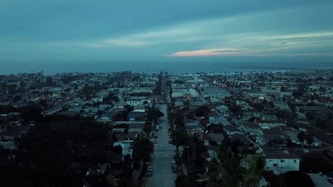 Drone Camera moves forward over sleepy beach town after sunset Stock Footage 84774286
