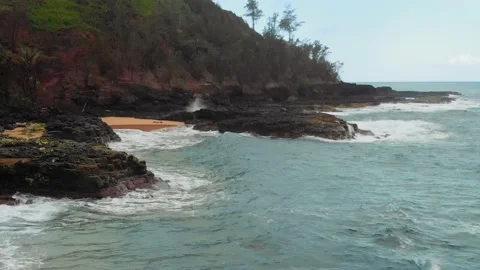 Drone camera moves over water splashing on a rocky shore at Kauai, Hawaii, USA Video stock 136418808