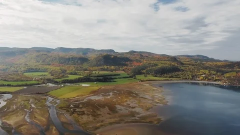 Drone camera moves over a yellow forest in the mountains on the shore of a pond Video stock 120647801