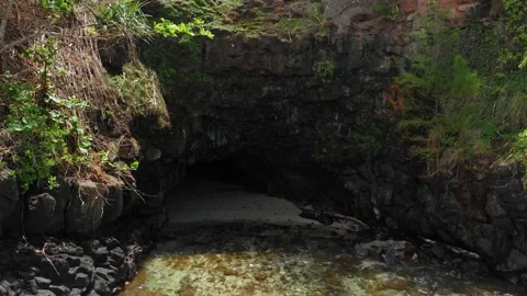 Drone camera receding out of the cave entrance in the ocean at Kauai, Hawaii Stock Footage 135950310