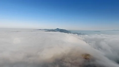 Drone camera shoots endless thick clouds and protruding mountain peaks in the Video stock 126679447