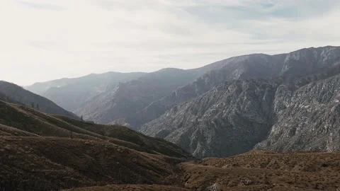 Drone camera smoothly moves over the gray mountains and shoots the horizon Video stock 145314415