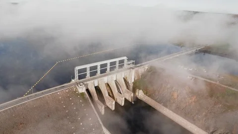 Drone camera is spinning over the river and the road and dams in autumn fog Video stock 120647770