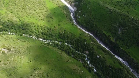 Drone camera tilts down from mountain peaks to rushing rivers in Kazakhstan 스톡 동영상 337142355