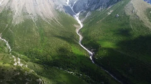 Drone camera tilts down revealing snow capped peaks and mountain river 库存影片 337141013