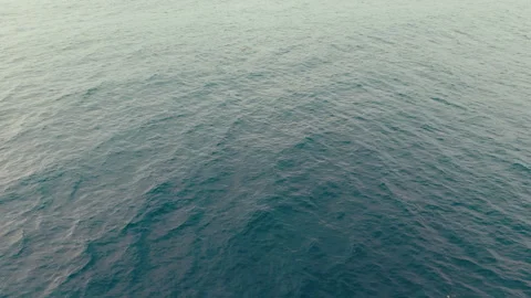 Drone camera tilts upward from Pacific Ocean toward dramatic dark clouds 库存影片 339252717