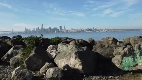 A drone capture moving left of San Francisco skyline with rocks in foreground 스톡 동영상 234081610