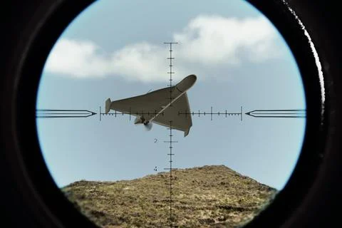 A drone is captured in a targeting scope against sky and clouds. Stock Photos
