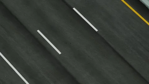 Drone-captured top-down view highlights an asphalt roadway. Stock Footage 309849226