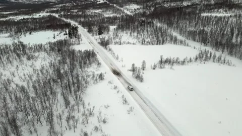 Drone captured video showcasing a van traveling along an asphalt road surrounded Stock Footage 330376589