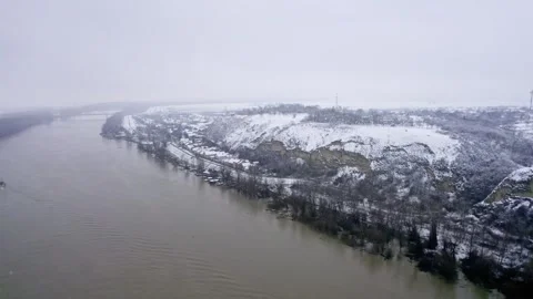 Drone captures a boat sailing on a river and a shore in cold foggy winter day Stock Footage 263358848