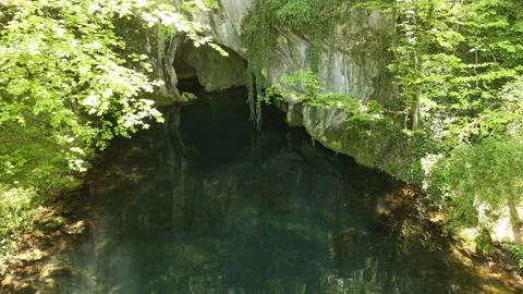 Drone captures a cave and turquoise lake in woods in nature reserve Krupajsko Stock Footage 270501671